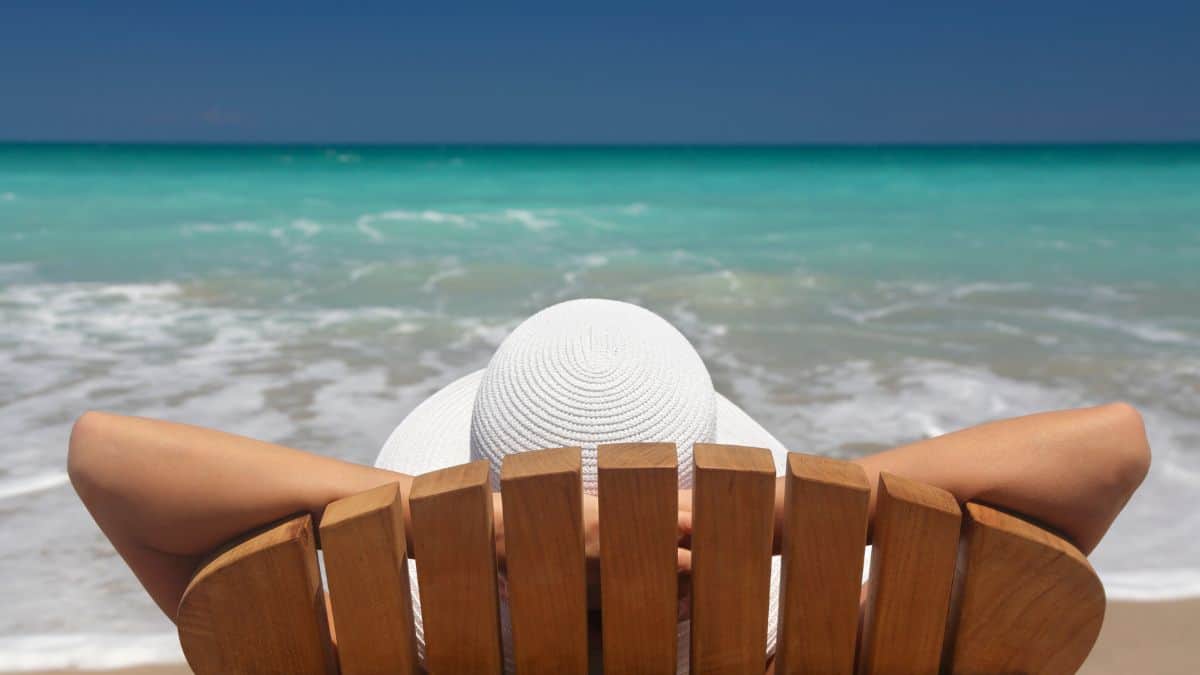A photo of a person sitting on a beach chair while looking at the beach
