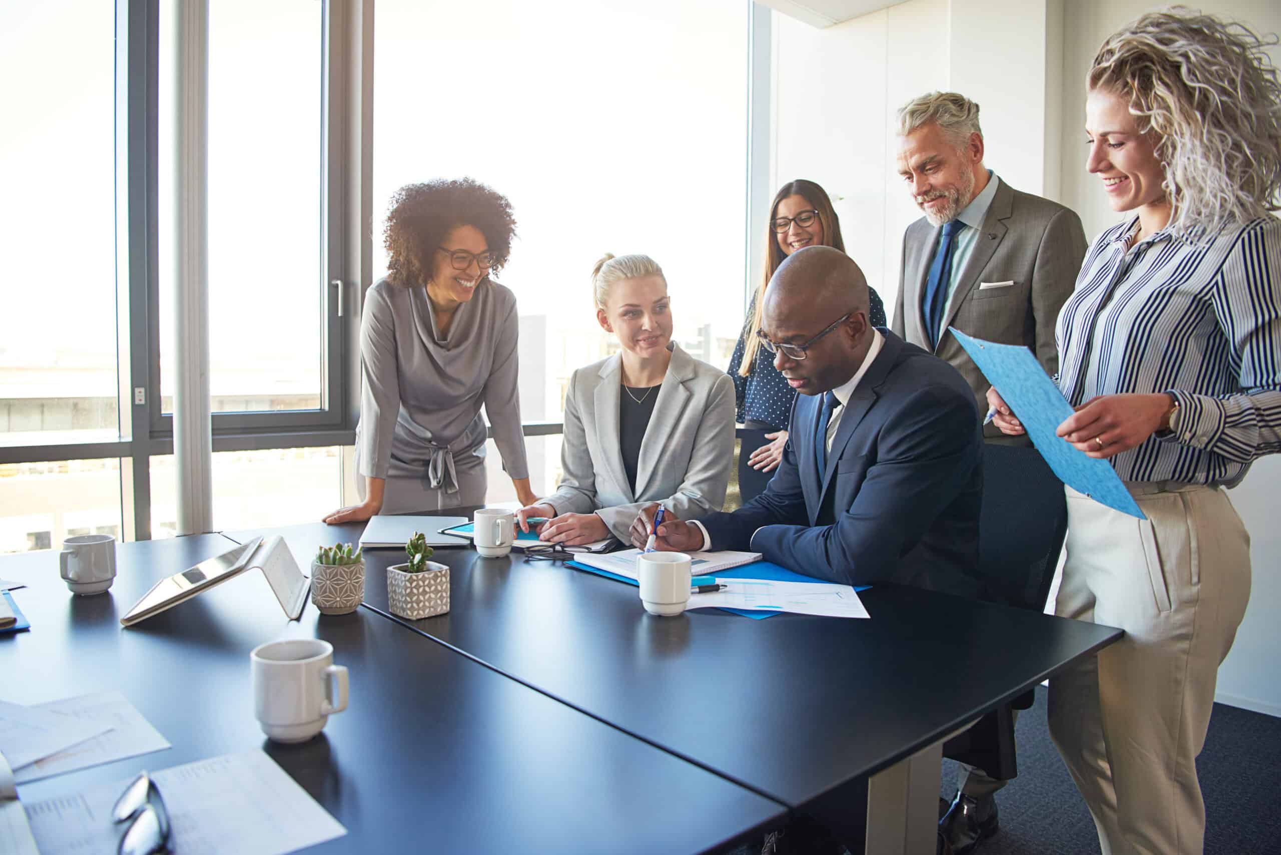 Diverse group of executives working together around a boardroom table Free Your Mind