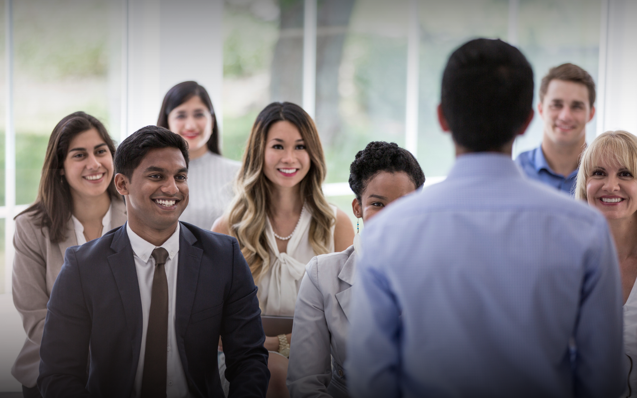A confident leader presenting to a diverse corporate team, showcasing the positive impact of executive coaching on communication, team morale, and organizational culture.